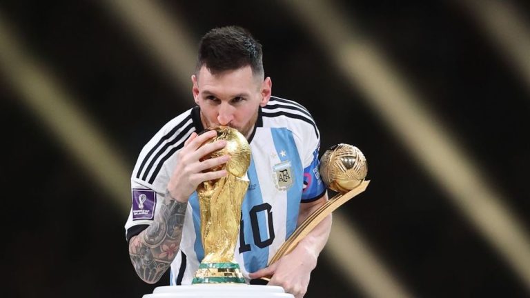 Lionel Messi kissing the FIFA World Cup trophy during the 2022 World Cup celebration